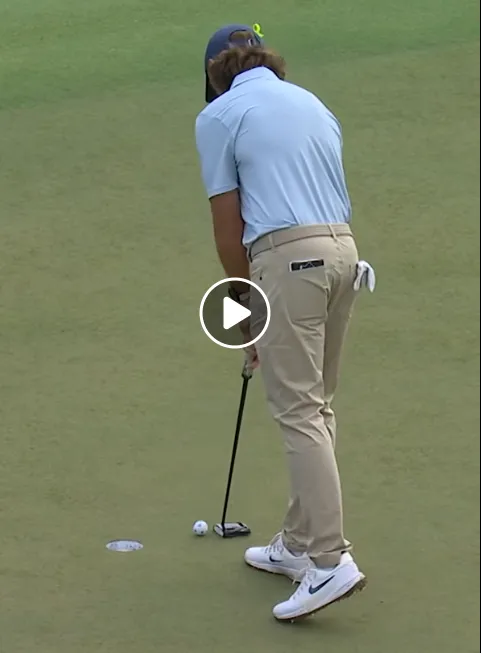 Fleetwood lifting the trophy while Fitzpatrick studies his yardage book.